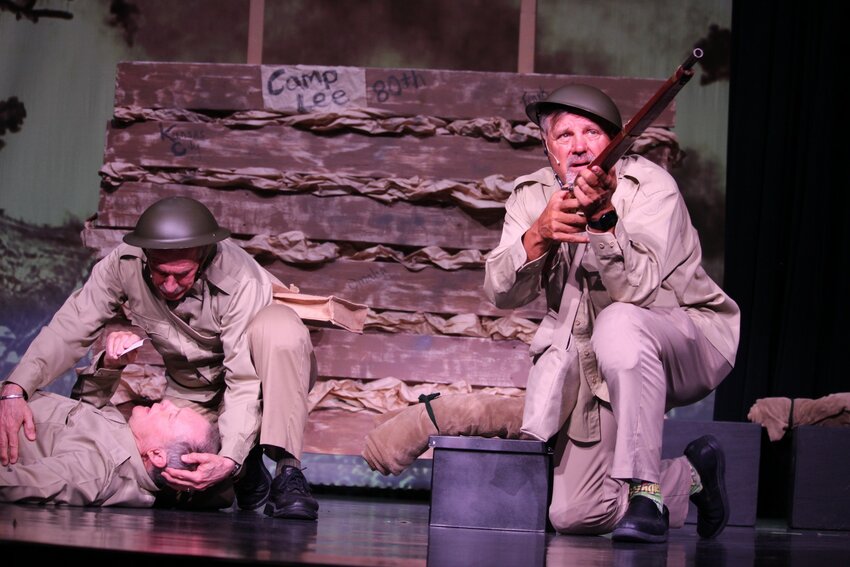 Pictured are Buddy (Fred LaMonica) cradling the head of Charlie (John Hobold) as Reese (Nick Missos) keeps watch.