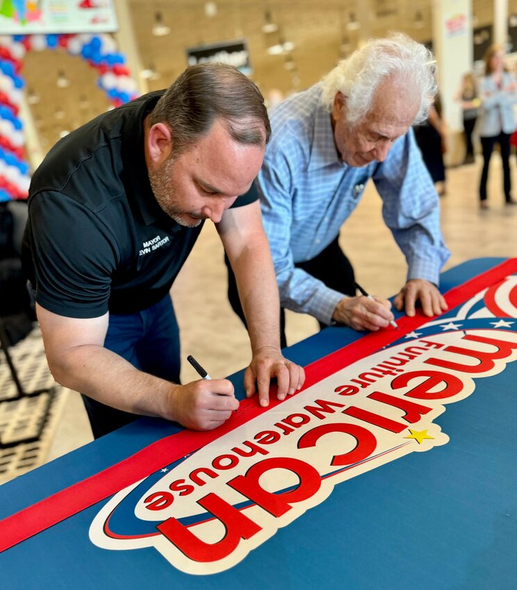 Surprise Mayor Kevin Sartor, left, and American Furniture Warehouse CEO Jake Jabs commemorate the opening of the new furniture store at Loop 303 and Waddell in the Prasada shopping center.