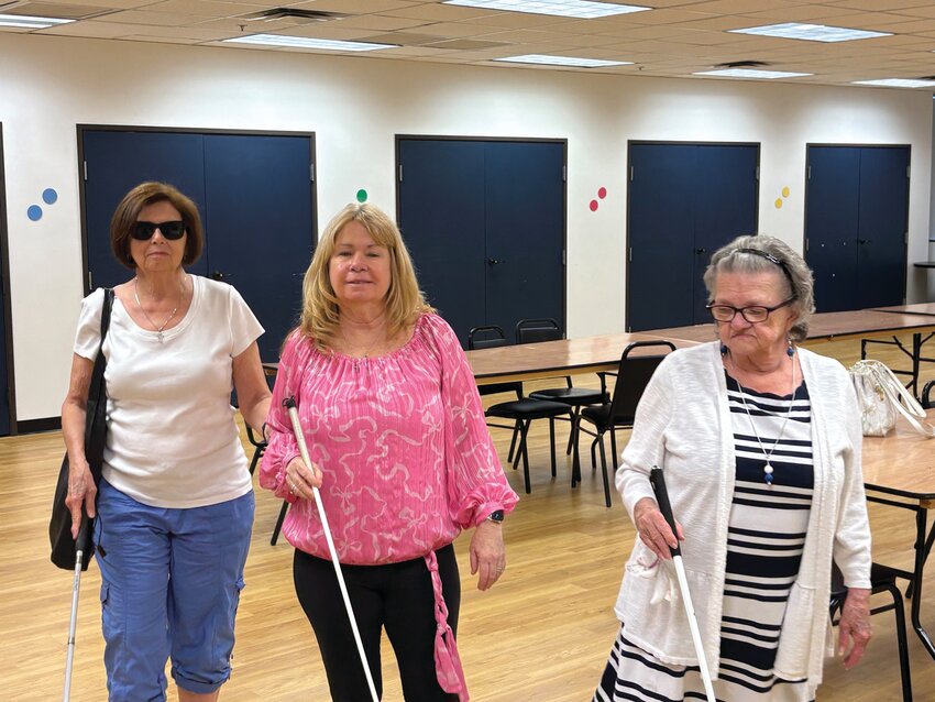 Glendale residents Cathy Rose, left, and Beverly Smith, right, along with Peoria resident Kimberly Fetterman, center, use their canes to help themselves walk out of the SAAVI Services for the Blind office in Phoenix June 13.