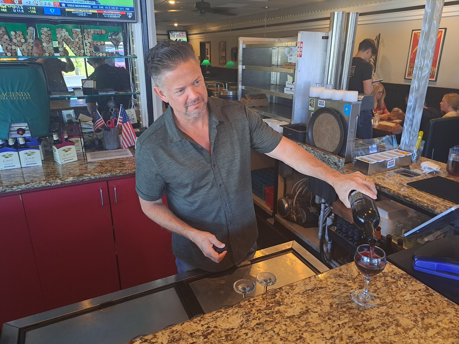 Floridino’s co-owner Shaun Kelley pours a glass of wine on a recent afternoon. Kelley founded Floridino’s, an Italian restaurant, with partner Jeff Weninger in 1996.