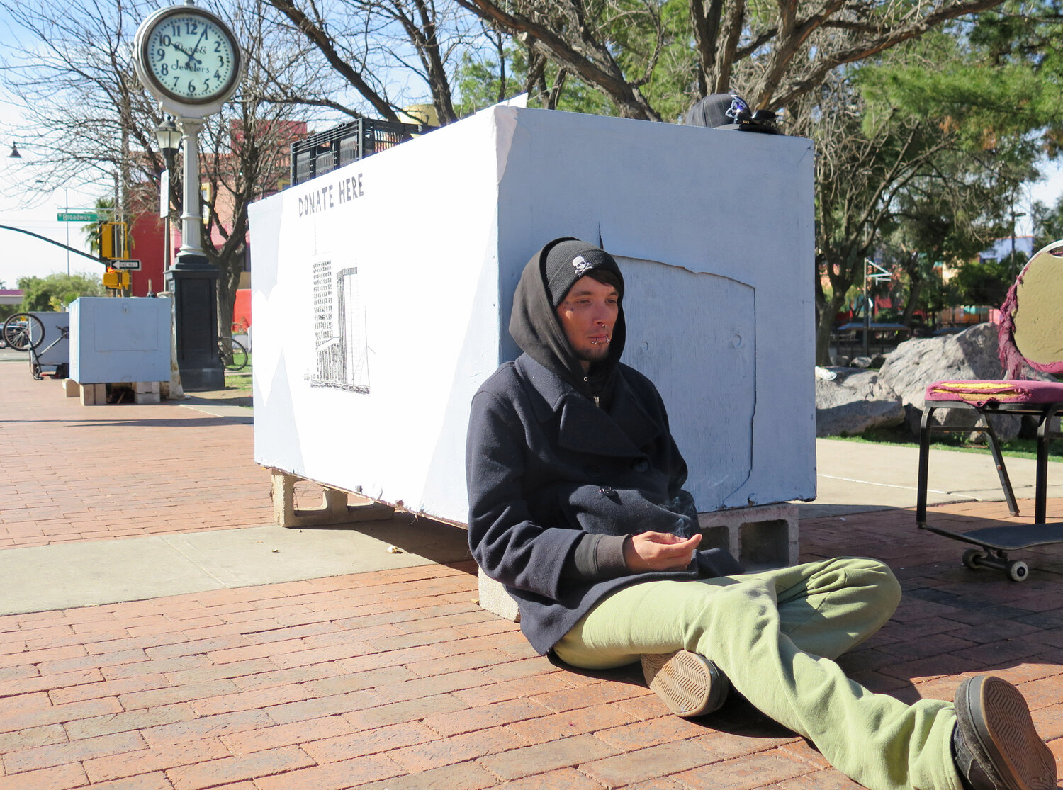 In this Feb. 25, 2015 photo, Sonny Clenny, 29, sits near a “dream pod” in downtown Tucson, at a park where protesters have made a permanent home. A lawsuit against the city of Tucson regarding sweeping homeless areas has been dropped, but those filing it are looking at other federal lawsuits that they claim make Tucson’s ordinances illegal, including a lawsuit involving the city of Phoenix. (AP Photo/Astrid Galvan)
