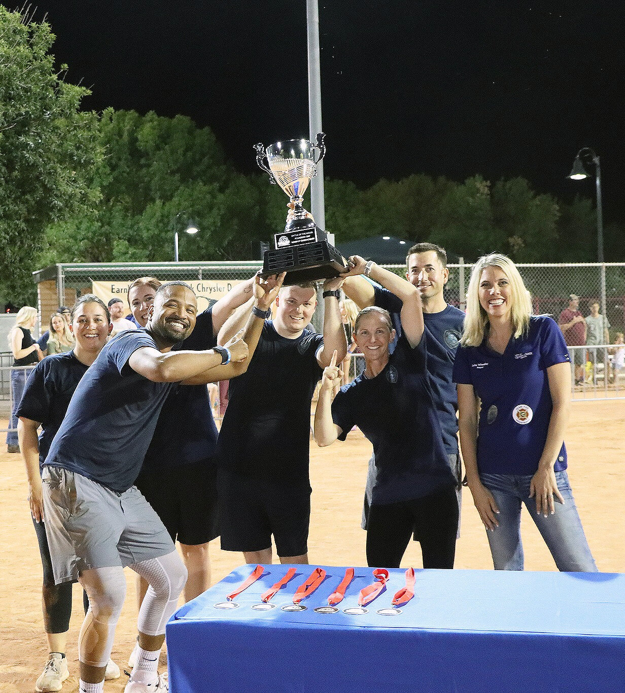 Members of the Queen Creek Police Department hold up their Battle of the Badge trophy, which they won during Founders’ Day celebrations. Queen Creek Mayor Julia Wheatley, far right, congratulated the team.