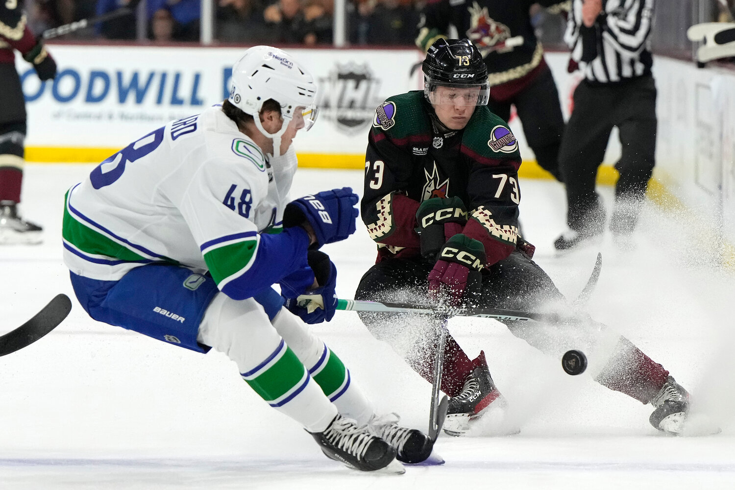 Coyotes right wing Jan Jenik, right, battles Vancouver defenseman Cole McWard for the puck April 13, 2023, in Tempe.