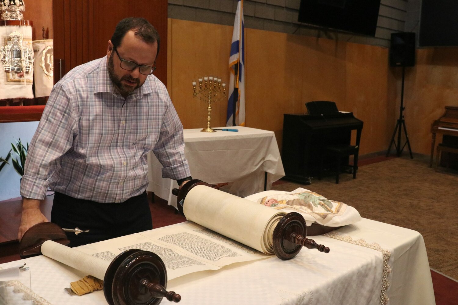 Rabbi Jeremy Schneider unrolls and reads the Torah scroll at Temple Kol Ami in Scottsdale on Sept. 20, 2023. (Photo by Jacob Snelgrove/Cronkite News)
