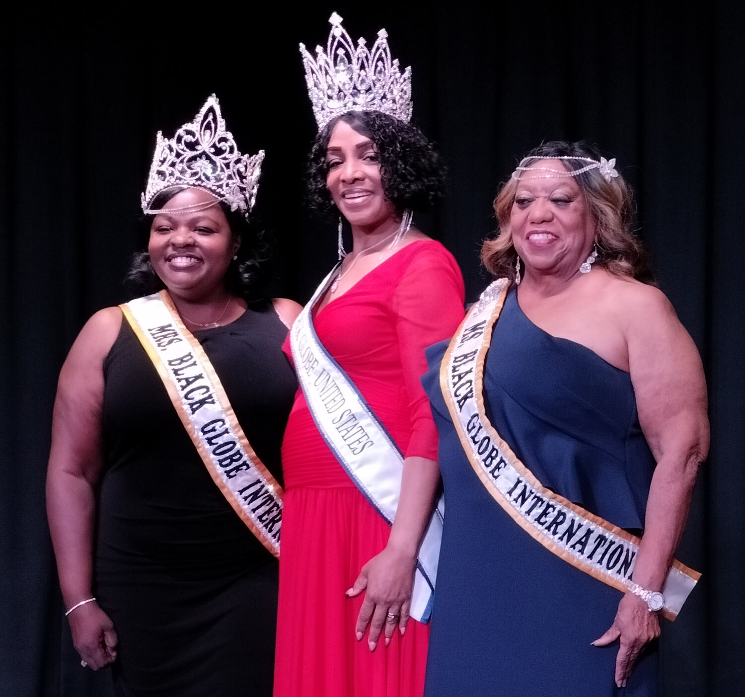 Ms. Black Globe International Queen Lorraine Taylor shown in blue dress with other queens.