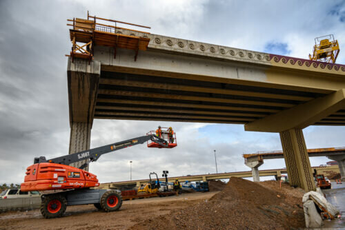 A crew uses a lift to reach the underside of the ramp that will eventually create the high-occupancy vehicle direct connections between I-10 and State Route 143 as part of the Broadway Curve improvement project.