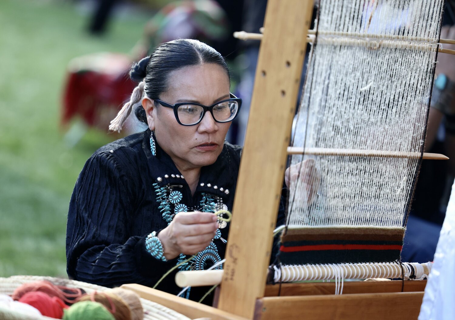 Sonja Morgan from the Navajo Nation showcases her rug-weaving process at the Arizona Indian Festival in Scottsdale on Feb. 3, 2024. (Photo by Marnie Jordan/Cronkite News)