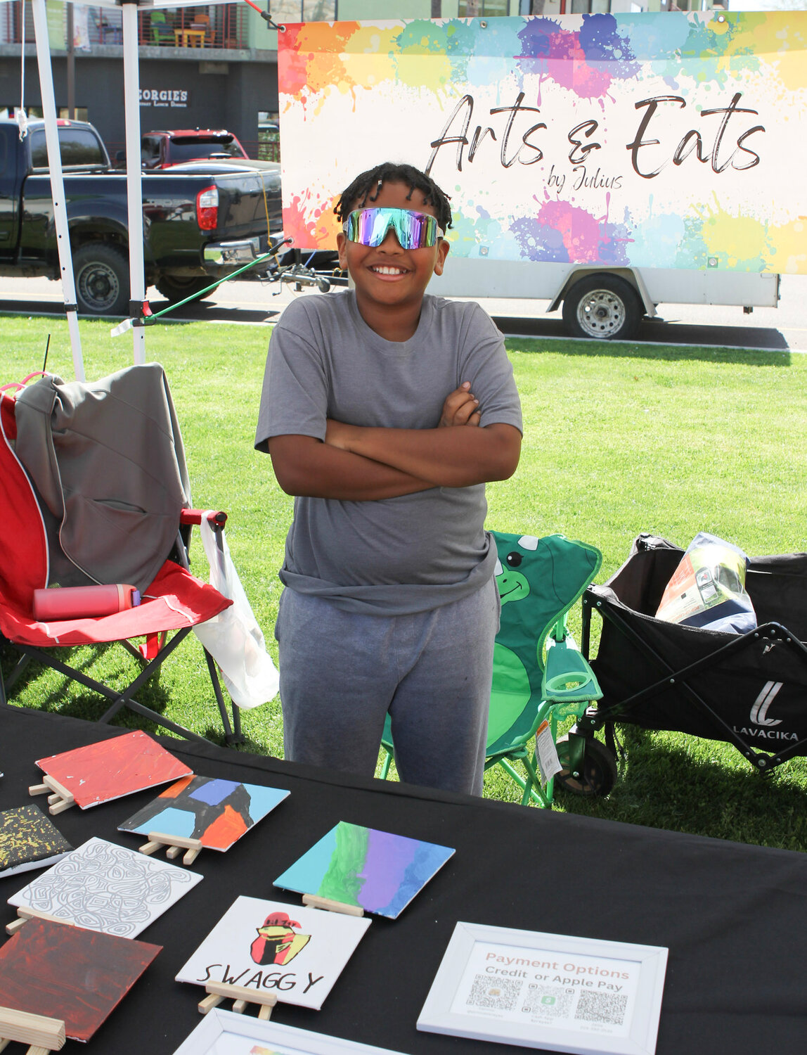 Julius Bradley proudly displays his homemade canvas art designs at the Children's Entrepreneur Market.