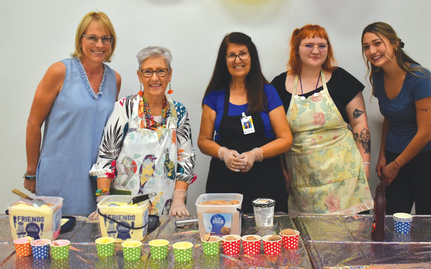 Preschool teachers serve ice cream to the students.