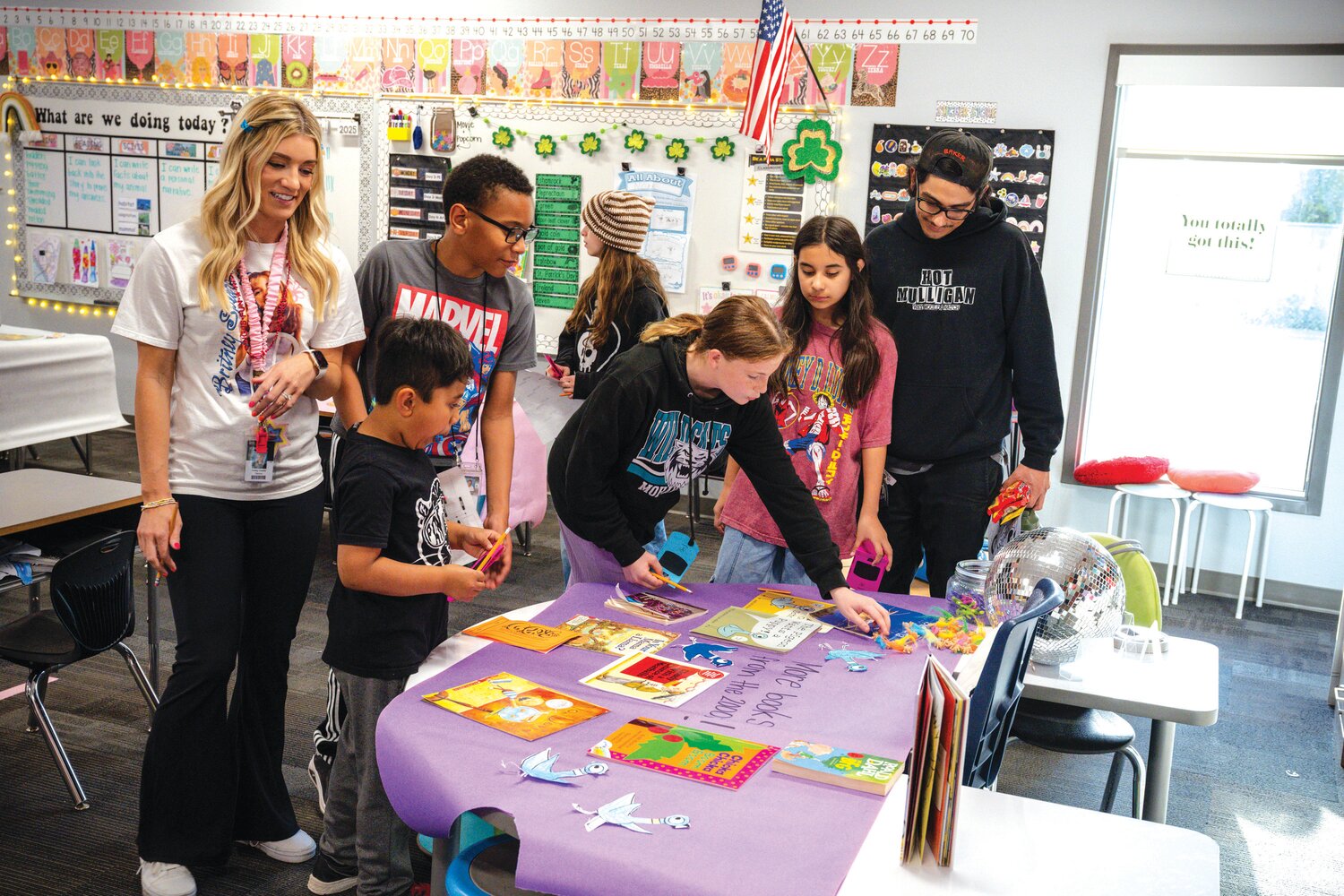First grade teacher Haley Witzig takes part in Title I Reading Night with excited friends and students.